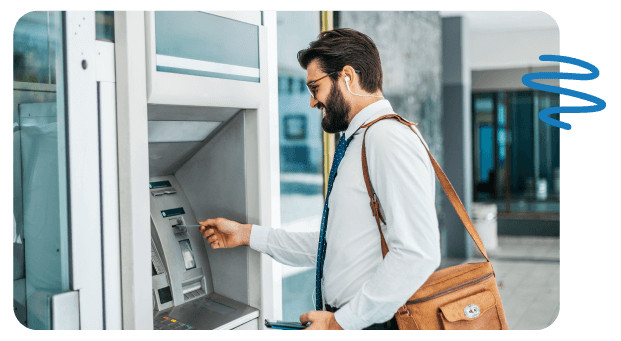 Business man carrying briefcase inserting card into ATM.
