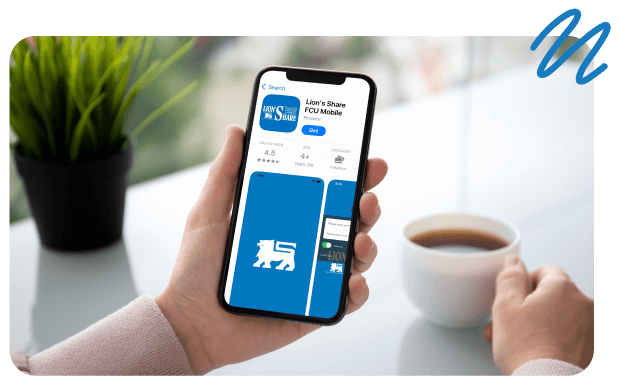 Person holding cell phone in hand with Lion's Share Mobile app on screen with other hand on coffee cup.