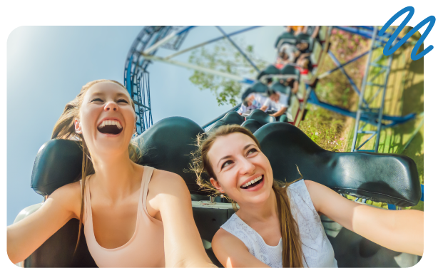 Happy, smiling ladies riding a rollercoaster.