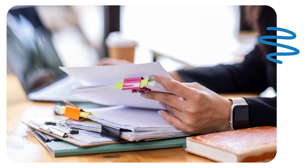 Woman sitting at desk looking through documents.