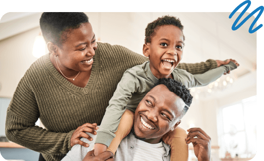 Family of three playing in living room and smiling.