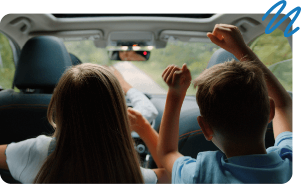 Kids with raising arms in the air sitting in backseat of car.