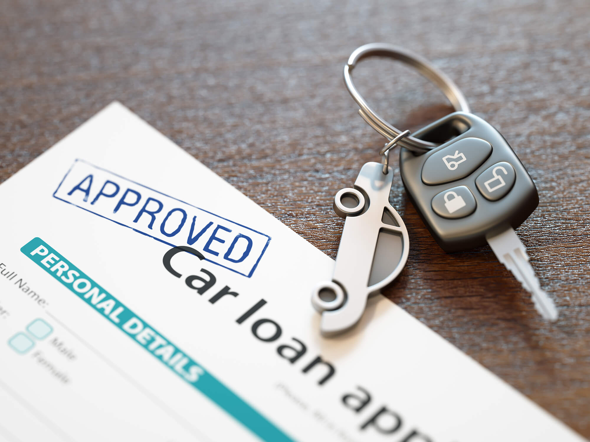 Car keys sitting on table next to Approved Car Loan application.