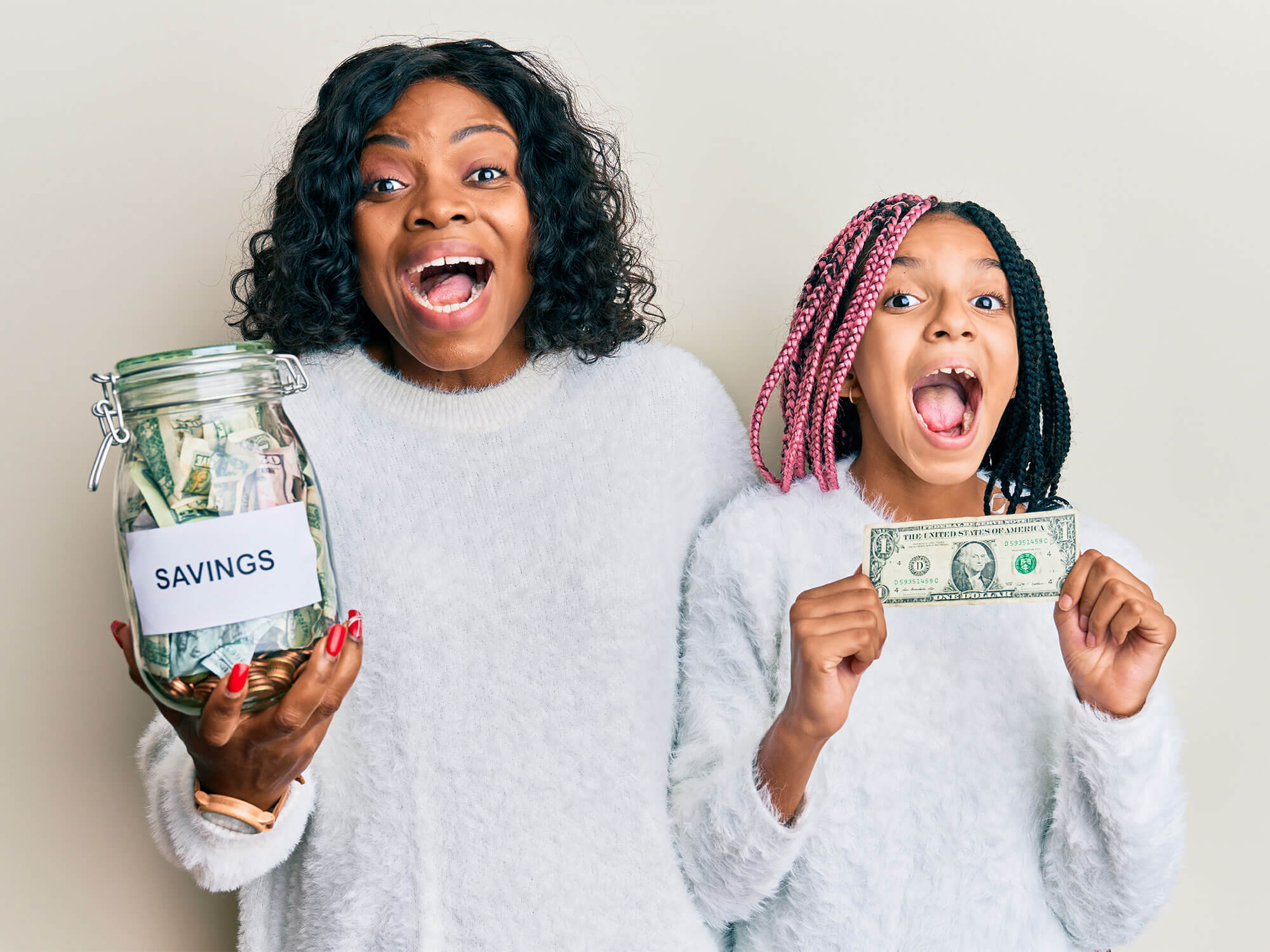 Excited mother and daughter holding money and Savings jar